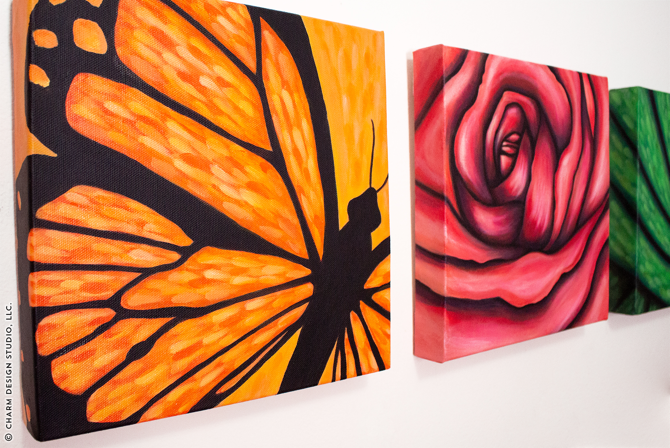 finished acrylic paintings on canvas hung up on wall | image © Charm Design Studio, LLC.